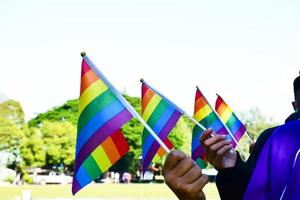 regenbogenfahnen, lgbt-symbol, in händen halten, konzept für lgbt-gemeinschaftsfeier im stolzmonat, juni 2023, auf der ganzen welt. foto