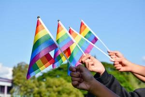 regenbogenfahnen, lgbt-symbol, in händen halten, konzept für lgbt-gemeinschaftsfeier im stolzmonat, juni 2023, auf der ganzen welt. foto