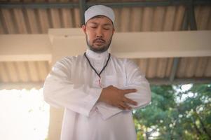 junger asiatischer muslimischer mann, der bei sonnenuntergang betet, ramadan-festkonzept foto