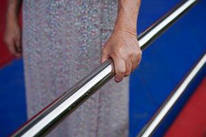 asiatische ältere alte patientin benutzt stützschiene auf rampe, handlauf sicherheitshaltegriff, sicherheit im pflegekrankenhaus. foto