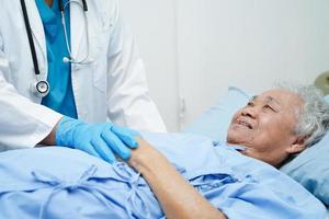 Ärztin Händchen haltend asiatische ältere Patientin, Hilfe und Pflege im Krankenhaus. foto