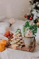 weihnachtsbonbons, mit glasur bemalter lebkuchen, lutscher und meringues in form von weihnachtsbäumen und mandarinen auf einem schönen tablett. hausgemachte Kuchen. Leckeres Essen für die Winterferien foto