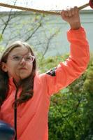 Teenager-Mädchen hält Seile zum Klettern auf dem Spielplatz foto