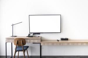 wohnzimmer innen führte tv-ständer an der weißen wand montiert mit holztisch im raum in modernem stil foto