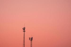 antenne sende signal telekommunikation in einem rosa orange himmelhintergrund foto