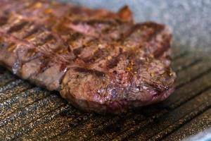 saftiges rindfleischsteak, das in der professionellen küche auf einer grillpfanne gekocht wird. Prime Steak Braten am Grill. leckere, moderne Küche. foto