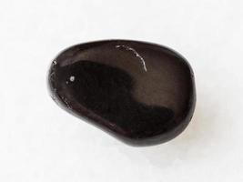 polierter schwarzer obsidian-edelstein auf weiß foto