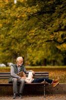 Großvater verbringt am Herbsttag Zeit mit seiner Enkelin auf der Bank im Park foto