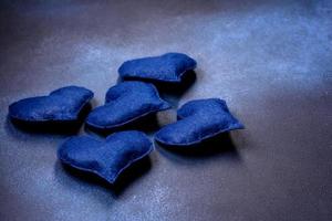 schöne Filzherzen in blauer Farbe auf dunkelblauem Betongrund foto