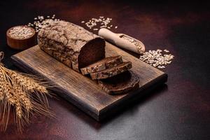 Ein Laib Schwarzbrot mit Getreidekörnern auf einem Holzschneidebrett foto