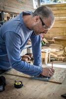 Porträt eines Tischlers, der in der Holzwerkstatt arbeitet. foto