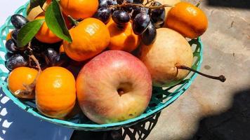 Nahaufnahme von Äpfeln, Birnen, Trauben und Orangen im grünen Korb 01 foto