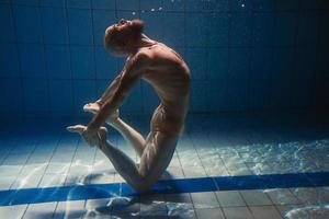 athletischer sportmann unter wasser im schwimmbad. Sport, Yoga, Freitauchkonzept foto