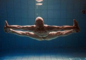 athletischer sportmann unter wasser im schwimmbad. Sport, Yoga, Freitauchkonzept foto