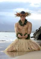 ein junger männlicher hula-tänzer gestikuliert das geben oder anbieten in einem hula-tanz. foto