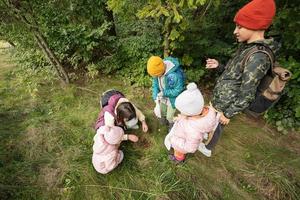 mutter und kinder suchen pilze im wilden wald. foto