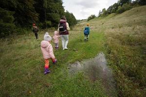 mutter und ihre kinder wandern durch den wald. foto