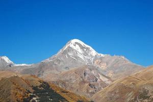 Blick auf den Berg Kasbek in den Bergen des größeren Kaukasus in Georgien im Herbst. foto