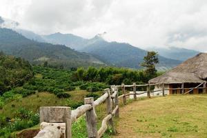 malerische Landschaft auf den Bergen, Holzzaun im Vordergrund und Häuser im Hintergrund. Yun Lai, Pai, Thailand. foto