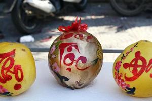 Drei Grapefruits, dekoriert für die Feier des vietnamesischen Neujahrs auf einem Markt in Hoi An, Vietnam. Die Inschrift ist übersetzt - Glück. foto