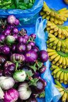 frische Auberginen und Bananen auf dem Straßenmarkt. lokaler morgenmarkt in luang prabang, laos. foto