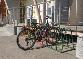 Fahrradparkplatz vor dem Gebäude, Fahrradparkplatz in der Nähe des Schuleingangs, farbiger Fahrradparkplatz foto