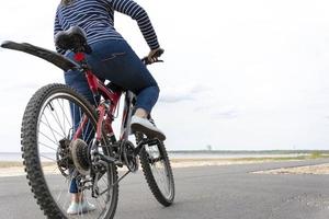 junge hübsche frau mit großen hüften blieb auf einem fahrrad stehen und schaute irgendwo hin foto