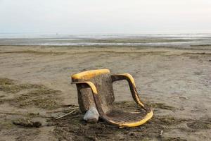 Alter Plastikstuhl an der Küste, Meeresbucht, Ökologie, Umweltverschmutzung angespült foto
