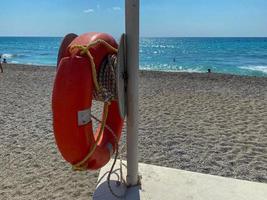 runde, nicht sinkende rote Rettungsboje zur Sicherheit, um das Leben von Ertrinkenden zu retten Touristen am Strand in einem warmen östlichen tropischen Land Southern Paradise Resort foto