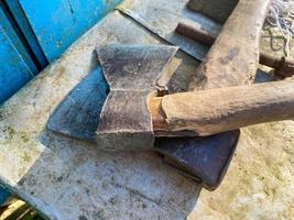 Satz von Eisenwerkzeugen Axt Hammer Nahaufnahme alter Holzgriff auf Brettern verwittert foto