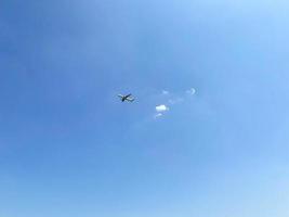 das flugzeug fliegt in den himmel unter den wolken. Ein weißes Flugzeug mit großen Flügeln bringt Touristen zur Ruhe. Reise über den Himmel foto