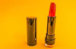 schöner, modischer, kosmetischer, glamouröser roter Lippenstift zum Auftragen von Make-up auf den Lippen auf gelbem, sanftem Hintergrund foto