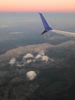 Blick auf die Wolken und die Flugzeugtragfläche von innen foto