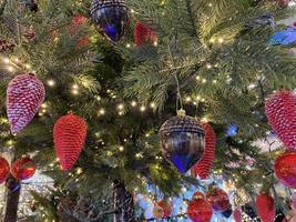 Weihnachtsdekoration. rosa, silberne und weiße kugeln auf weihnachtsbaumast. Weihnachtskarte. Weihnachtsspielzeugkugel, die am Zweig der Fichte hängt. neujahrsbaum geschmückt mit einem garland.stylish weihnachtsbaum foto