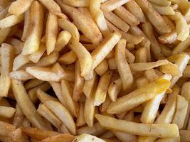 leckere gelbgoldene pommes frites, rustikale in öl gebratene kartoffeln, fast food. der Hintergrund. Textur foto