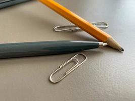 Automatischer grüner Kugelschreiber und Bleistift mit Büroklammern zum Schreiben auf Ihrem Schreibtisch. geschäftliche Arbeit