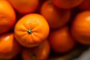 Korb mit Mandarinen- oder Orangenfrucht auf einem grauen karierten Hintergrund. foto