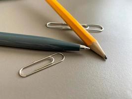 Automatischer grüner Kugelschreiber und Bleistift mit Büroklammern zum Schreiben auf Ihrem Schreibtisch. geschäftliche Arbeit