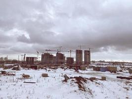 Bau von Häusern, ein Einkaufszentrum aus Betonblöcken in der Stadt. Bau eines neuen Wohnquartiers im Winter für das Leben unter grauem Himmel foto