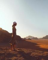 Frau auf Klippe Sonnenuntergang im Wadi Rum genießen foto