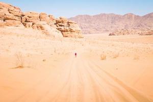 Fröhliche, fröhliche Touristin mit erhobenen Händen in der Wadi-Rum-Wüste auf Wanderung im Urlaub im Wadi-Rum. beliebte Wadi-Rum-Wüste in Jordanien foto