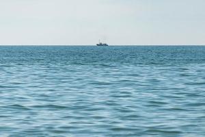 Fischereischiff auf See. einsamer Bootstrawler geht in den Hafen, um den Fischfang zu verkaufen. ruhiges klares sonniges Wetter. schöner Horizont der Meereslandschaft. foto