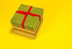 bunte Weihnachtsgeschenkbox auf gelbem Hintergrund foto