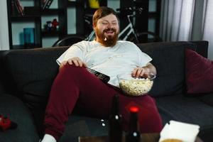 Mann, der Popcorn isst und fernsieht foto