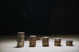 geschäftsmann, der münzen hält, die in glas setzen. konzept spart geld für die finanzbuchhaltung foto