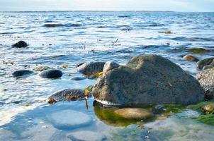großer Stein im Wasser am Strand im Meer. Dänische Küste an einem sonnigen Tag foto