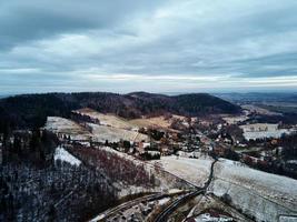 Winterlandschaft mit Dorf in der Nähe von Bergen foto