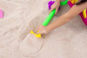 Kinder spielen im Sand in der Nähe des Strandes foto