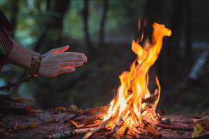 nahaufnahme der hände, die sich über dem lagerfeuer konzeptfoto erwärmen foto