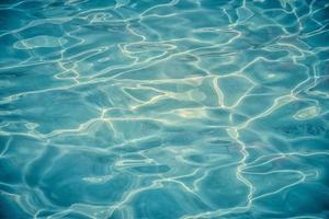 azurblaues klares wasser in einem schwimmbad mit sonnenreflexion foto